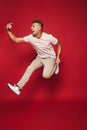 Full length photo of optimistic man in striped t-shirt jumping a
