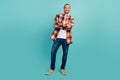 Full length photo of optimistic satisfied man wear flannel shirt jeans holding palms folded isolated on turquoise color Royalty Free Stock Photo