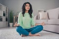 Full length photo of peaceful calm dark skin woman sit floor meditate good mood indoors home inside house