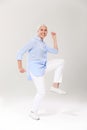 Full-length photo of playful old lady, having fun over white background