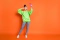 Full length photo portrait of girl making v-sign near eye holding phone in one hand laughing taking selfie isolated on Royalty Free Stock Photo