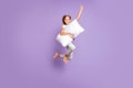 Full length photo of positive cheerful funny kid jump raise fist ahead imagine she strong superhero fly with pillow wear