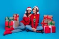 Full length photo of positive cute women santa elves wear ornament pullovers packing x-mas gifts isolated blue color