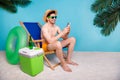 Full length photo of positive funky shirtless man straw hat chatting instagram twitter telegram facebook isolated blue Royalty Free Stock Photo
