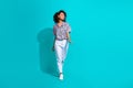 Full length photo of positive optimistic girl going store center looking empty space banner ad isolated on cyan color