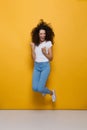 Full length photo of positive woman 20s with curly hair having f