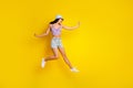 Full length photo of pretty adorable lady wear striped crop top cap jumping high empty space isolated yellow color Royalty Free Stock Photo