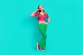 Full length photo of pretty adorable schoolgirl wear pink crop top flared pants showing v-sign isolated turquoise color