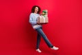 Full length photo of pretty carefree girl dressed ugly christmas sweater walking holding presents pile  red Royalty Free Stock Photo