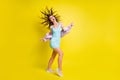 Full length photo of pretty cheerful girl open mouth dancing hair flying isolated on yellow color background Royalty Free Stock Photo