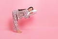 Full length photo of pretty cute young lady nightwear standing lying pillow empty space isolated pink color background