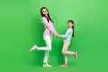 Full length photo of pretty excited little girl mom dressed casual clothes dancing holding arms isolated green color Royalty Free Stock Photo