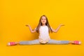 Full length photo of pretty funky school girl wear white t-shirt sitting split legs compering arms empty space isolated Royalty Free Stock Photo