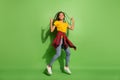 Full length photo of pretty funny dark skin woman wear yellow t-shirt dancing showing rock sign  green color Royalty Free Stock Photo
