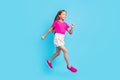 Full length photo of pretty nice happy girl jump up run empty space hurry sale isolated on pastel blue color background