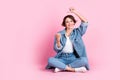 Full length photo of pretty sweet woman wear jeans shirt sitting floor legs crossed showing empty space  pink Royalty Free Stock Photo