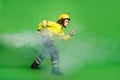 Full length photo of purposeful pretty young firewoman dressed uniform stalking through smoke isolated green color