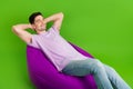 Full length photo of satisfied man closed eyes wear trendy clothes hold hands behind head empty space  on green Royalty Free Stock Photo