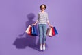 Full length photo of shiny buyer lady dressed casual clothes holding colorful bargains isolated purple color background