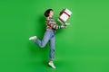 Full length photo shiny excited lady dressed colorful pullover jumping high catching big present box isolated green