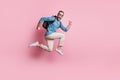 Full length photo of sweet funny man dressed blue sweater eyewear rucksack jumping parachute isolated pink color Royalty Free Stock Photo