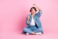 Full length photo of sweet impressed woman wear jeans shirt sitting floor showing thumbs empty space isolated pink color Royalty Free Stock Photo