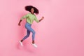 Full length photo of sweet shiny girl dressed green pullover running fast jumping high empty space isolated pink color Royalty Free Stock Photo