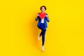 Full length photo of sweet shiny woman wear blue jacket rising big red heart jumping high isolated yellow color