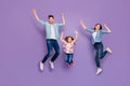 Full length photo of three cheerful jumping high family members wear casual clothes purple background