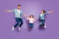 Full length photo of three rejoicing jumping high family members wear casual clothes purple background