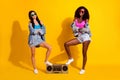 Full length photo of two funky cool ladies boombox folded arms summer wear jeans jacket isolated on yellow color