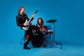 Full length photo two funky popular rock band perform new composition man play guitar woman drum drumstick enjoy punk