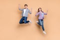 Full length photo of two people crazy lady guy jumping high showing v-sign symbol celebrating successful win wear casual