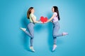 Full length photo of two people lesbians couple ladies jump high up hold big red paper heart lovers valentine day Royalty Free Stock Photo