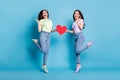 Full length photo of two people pretty lesbians couple ladies jump high up hold big red paper heart lovers valentine day Royalty Free Stock Photo