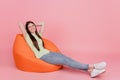 Full length photo of woman sitting in beanbag chair rest sleep nap isolated on pastel pink colored background Royalty Free Stock Photo