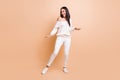 Full length photo of young beautiful girl excited happy positive smile have fun enjoy dance isolated over beige color Royalty Free Stock Photo