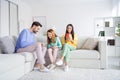 Full length photo of young cheerful family happy positive smile read browse cellphone sit couch home Royalty Free Stock Photo