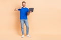 Full length photo of young cheerful man show thumb-up recommend perfect feedback use laptop isolated over beige color Royalty Free Stock Photo