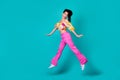 Full length photo of young chinese crazy excited girl jump up air go weekend after work happy isolated on cyan color Royalty Free Stock Photo