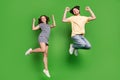 Full length photo of young couple happy positive smile jump up rejoice victory isolated over green color background