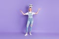 Full length photo of young girl happy positive smile hold soccer ball head have fun isolated over violet color Royalty Free Stock Photo