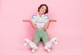 Full length photo of young girl happy positive smile shrug shoulders roller skater isolated over pastel color background Royalty Free Stock Photo