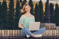 Full length photo of young girl happy positive smile sit bench use laptop browse internet online city outdoors Royalty Free Stock Photo