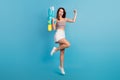 Full length photo of young girl happy positive smile win game water pistol jump up isolated over blue color background