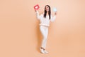 Full length photo of young girl happy smile look empty space hold paper card message info isolated over beige color Royalty Free Stock Photo