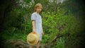 Full length photo of a young girl holding a straw hat in her hands Royalty Free Stock Photo