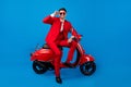 Full length photo of young handsome guy happy positive smile sit bike cool sunglass over blue color background