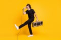 Full length photo of young man hold retro boombox mic open mouth raise leg wear black t-shirt pants white sneakers