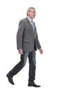 full length picture of a mid aged business man walking towards the camera and smiling. Royalty Free Stock Photo